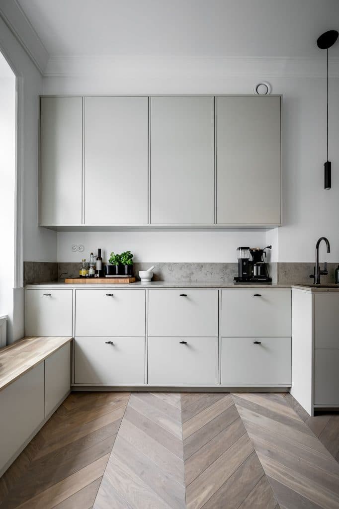 Ljusbeige kök med släta luckor och Jura Grey bänkskiva 